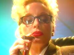 Blonde mature lady with glasses smokes a cigar and plays with her tits